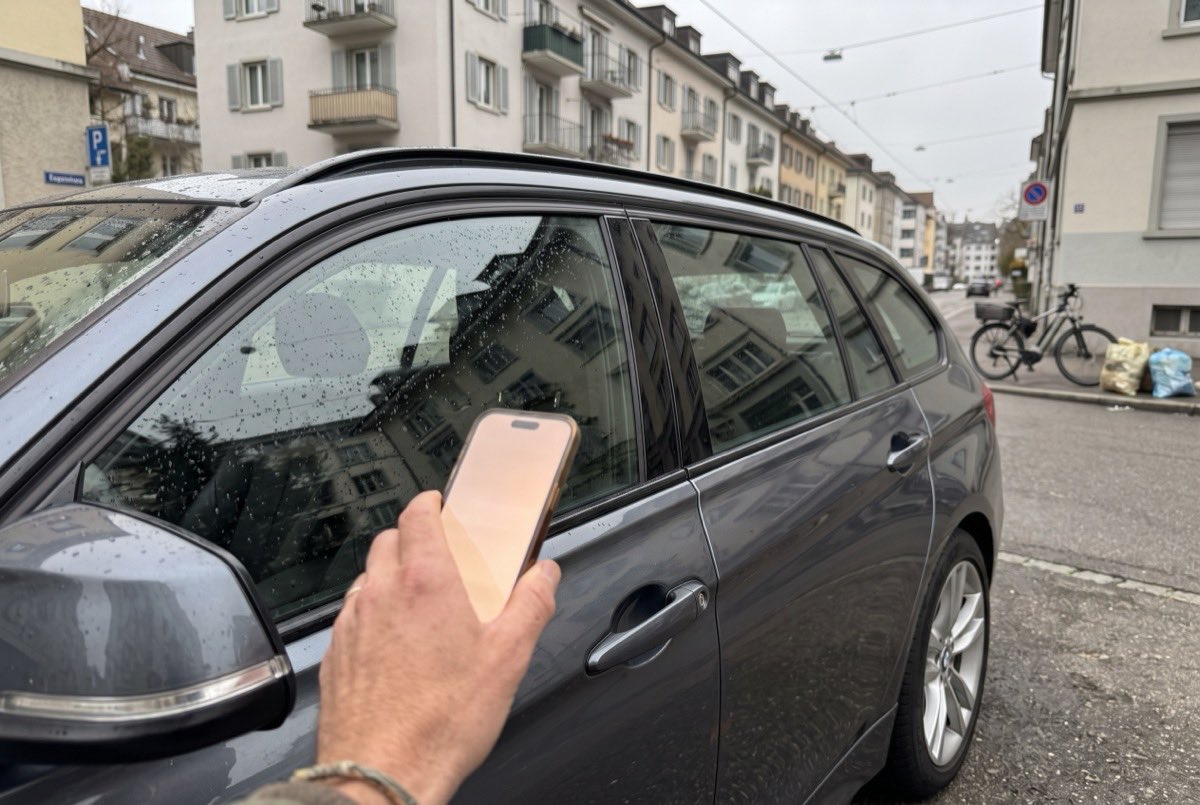 Hand mit dem Handy an der Fahrertür eines DRAIV-Autos, schlüssellos geöffnet